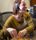 craigslist_porttix web-42 a box office worker in a yellow sweater smiles with a head set on. Her hands are rifling through a will call box, but she is making eye contact with someone out of shot to the right of the photographer.